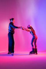 child skater athlete holding hands of her trainer, training for competition, photo on pink background in a studio
