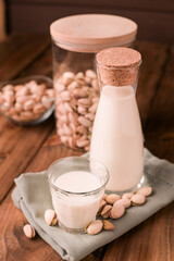 fresh homemade pistachio milk in a transparent bottle and pistachio nuts. vegetarian alternative to milk. Concept of lactose-free products and diet food. High quality photo