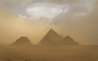 Fototapeta na wymiar Panoramic view of the pyramids of Gizah in Cairo, Egypt, during a sandstorm.