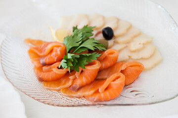 Salmon fillet on a plate. Slices of red fish with herbs.