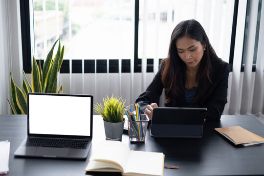 Portrait of cheerful asian woman with casual life on desk in home office. Concept of young business people working at home.