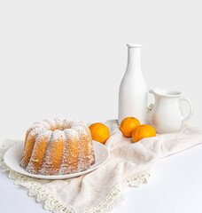 cupcake on a white napkin, two tangerines and a white background