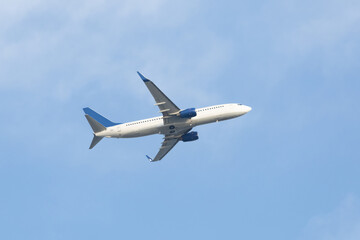Fototapeta na wymiar White passenger plane taking off