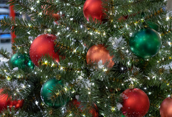 Obraz na płótnie Canvas Red and green Christmas balls on a Christmas tree with a garland.