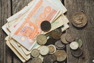 monetary unit of the Ukrainian state coupon and coins of the ussr lie on the table, old soviet...