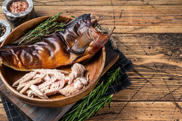 Fillet of Hot smoked fish pike perch or zander in a wooden plate with herbs. wooden background. Top...