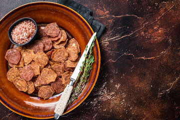 Dried smoked Meat Jerky from beef and pork meat. Dark background. Top view. Copy space