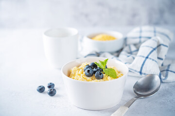 Corn porridge with fresh blueberries in a bowl