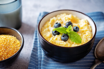 Corn porridge with fresh blueberries in a bowl