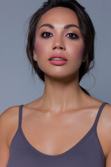 Beautiful brunet model woman face with brown eyes and perfect make-up . Portrait of beauty young brunet girl with pink lips. Female face with clear skin close-up. Skincare