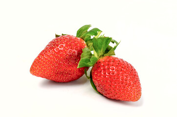 Fresh strawberries whole and cut on a white background