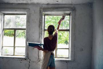 woman paints house renovation interior room painter