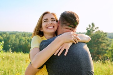 Portrait of happy adult hugging couple on summer sunny day