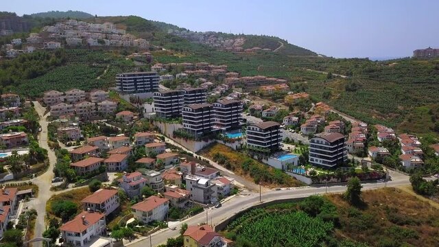 Resort view from a helicopter.Clip. A beautiful resort area with hotels, green parks, views of sports fields and large green mountains in the background