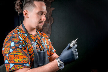 Tattoo artist poses for the camera in tattoo studio