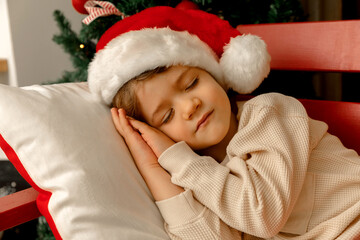 Fototapeta na wymiar A child with Santa Clause sleeps and smiles at bokeh background