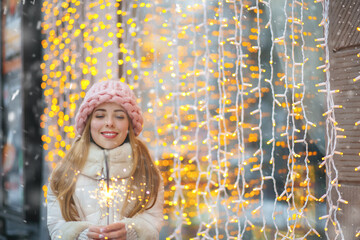 Obraz premium Beautiful lady enjoying winter holidays with bengal lights