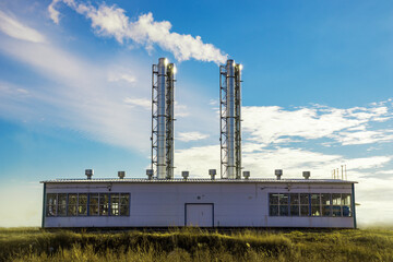 Utility building of mini thermal power plant with smoking chimneys