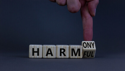 From harmful to harmony. Businessman turns the wooden cube and changes word harmful to harmony....