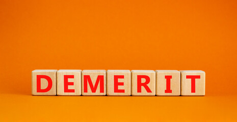 Demerit symbol. The concept word Demerit on wooden cubes. Beautiful orange table, orange background, copy space. Business and demerit concept.