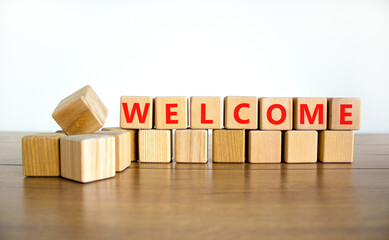Welcome and support symbol. The concept word Welcome on wooden cubes. Beautiful wooden table, white background, copy space. Business, welcome and support concept. © Dzmitry