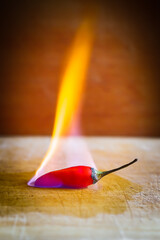 Burning red chili peppers on a wooden board
