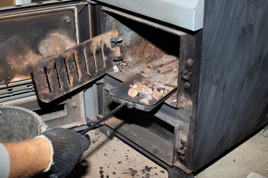 Cleaning The Solid Fuel Boiler From The Remains Of Firewood And Coal. Boiler With An Open Damper. Heating Efficiency In The House