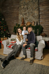 mom and dad with their son on the background of a Christmas tree in New Year's decorations