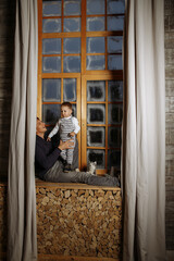 Fototapeta na wymiar dad and son are sitting on the windowsill against the background of the window