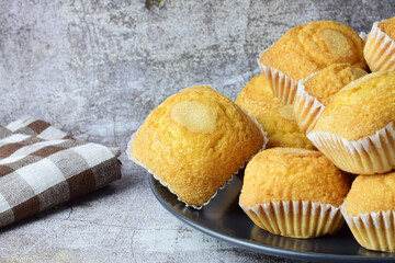 Plate with stacked muffins on stone background.