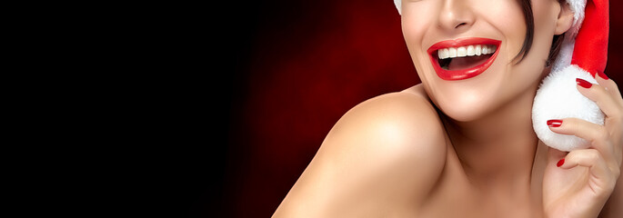 Christmas beautyt. Festive sexy red lips of a beautiful Christmas model with a gorgeous smile in a...