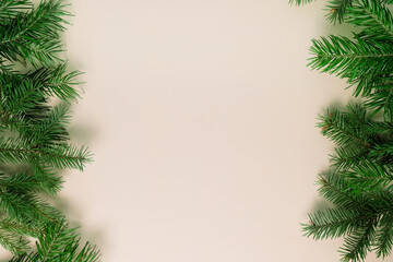 Background of Christmas tree branches on neutral background.