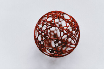 Christmas ball with macrame-style weaving,handmade decor in eco-style,hands close-up,top view. Christmas, New Year and eco-friendly concept