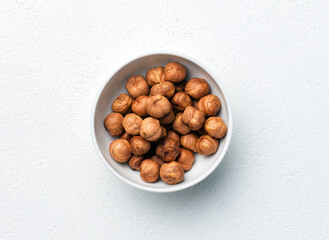 Hazelnuts in bowl on white table