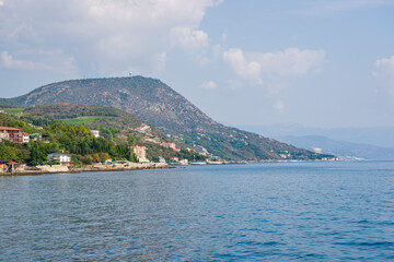 Wooded mountain with residential buildings near the sea