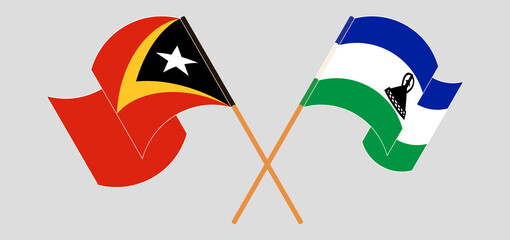 Crossed and waving flags of East Timor and Kingdom of Lesotho