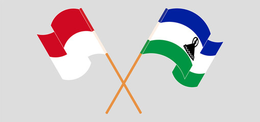 Crossed and waving flags of Monaco and Kingdom of Lesotho