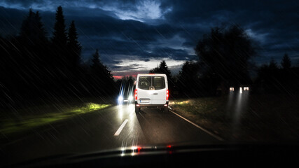 Traffic front - and backlights in road - dazzled and poor visibility through the windscreen in rain with poor vision and wet conditions at night.