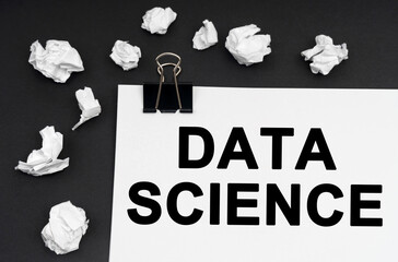 On a black background, there are crumpled pieces of paper and paper with the inscription - DATA SCIENCE