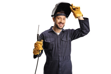 Young welder in a uniform and a shield on his head holding a welding machine - obrazy, fototapety, plakaty