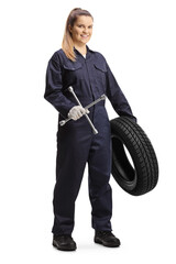 Female auto mechanic worker holding a tire and a lug wrench