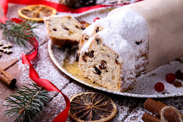 Fototapeta premium Dresdner Stollen is a Traditional German Cake with raisins on wooden background. Fruit cake for the Holiday.