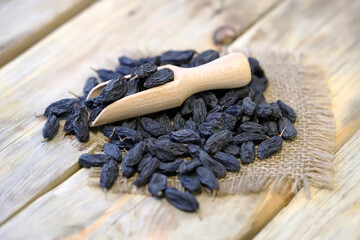 Selective focus. Large blue raisins in a wooden spatula.