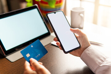 Woman using smartphone with credit card, ordering online shopping. Working from home concept