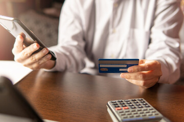 Woman using smartphone with credit card, ordering online shopping. Working from home concept