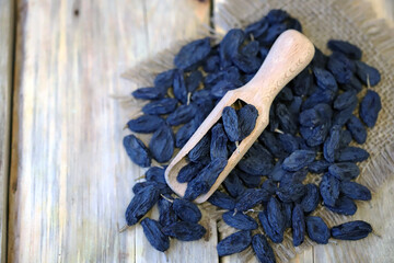 Selective focus. Large blue raisins in a wooden spatula.