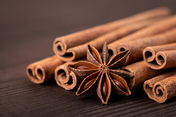 Beautiful composition of cinnamon and star anise against dark wooden background. Fresh aromatic spices
