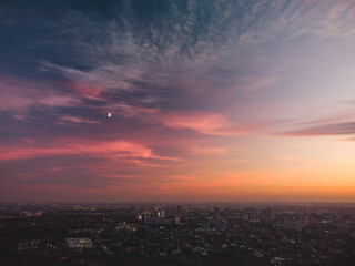 Aerial scenic vivid colorful sunset clouds on epic skyscape with moon. Kharkiv city center, residential district streets in evening light