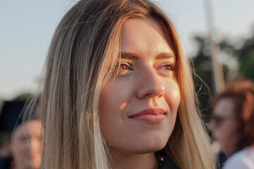 Portrait of a woman. Close up photo. She looks forward and smiling. Beauty sunshine girl side profile portrait. Pretty happy lady enjoying summer outdoors. emotion life success mind peace concept. © burhan