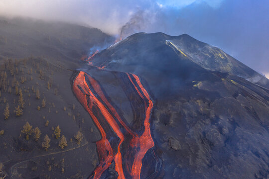 Aerial top down view of lava floating down the Volcan Cumbre Vieja, a volcano during eruption near El Paraiso town, Las Manchas, La Palma Island, Canary Islands, Spain.